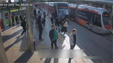 驚險！土耳其女闖電車鐵軌險被撞　被保全緊急拉回月台