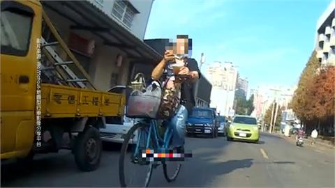 兩手拿手機、飲料　腳踏車騎士直闖紅燈遭撞倒地