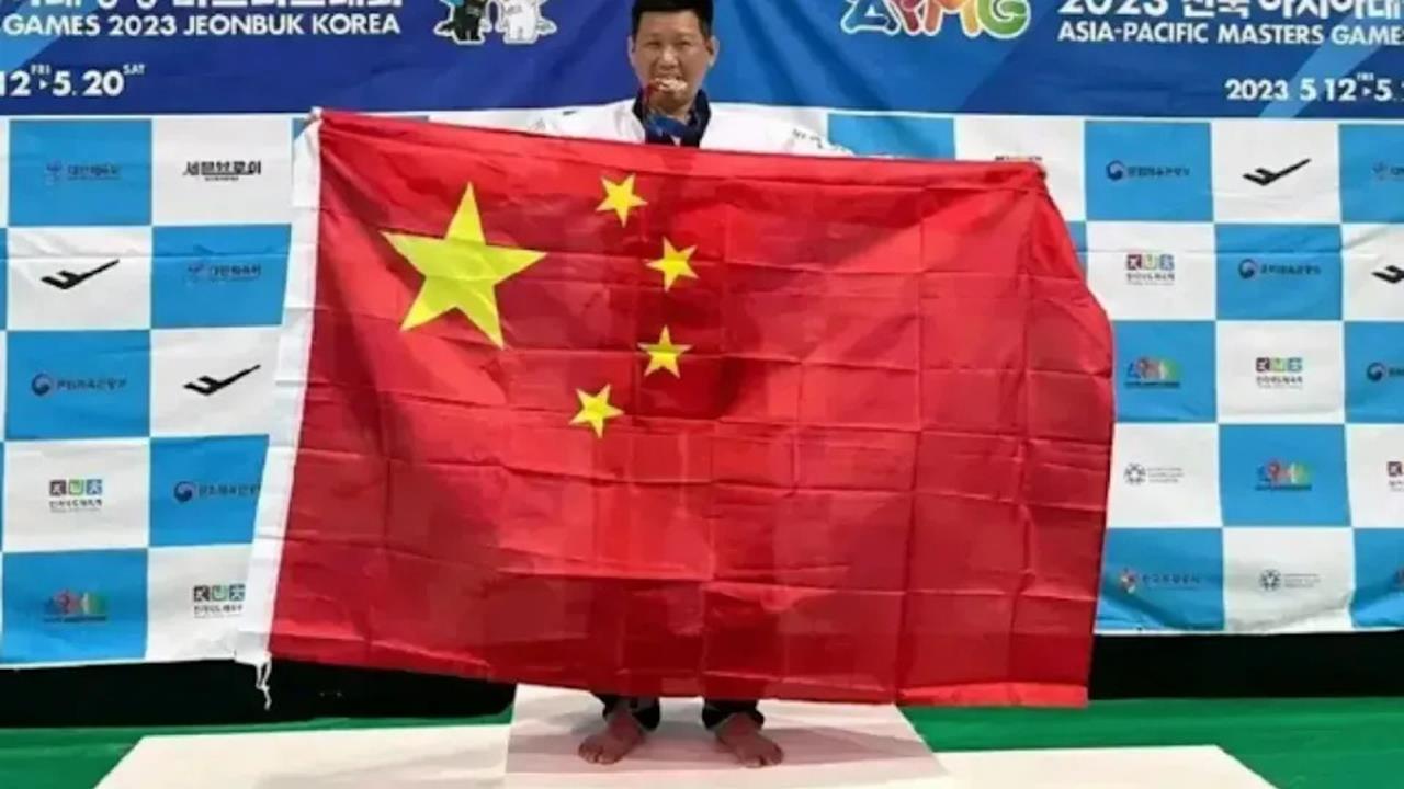 跆拳道教練李東憲曾在領獎台高舉五星旗。(圖/取自微博)