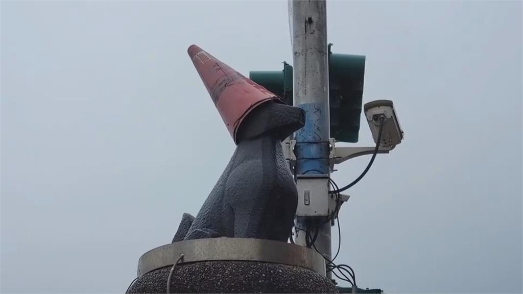 鋒面過境基隆落雨　狗石像帶「三角錐」遮雨