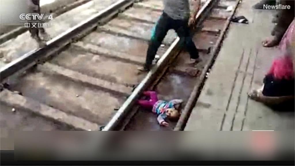 驚險瞬間！印度女嬰摔落鐵道 火車疾駛竟無傷