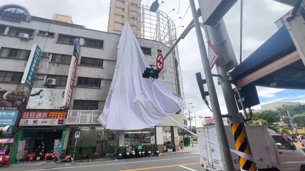 大太陽卻吹強風？高雄廣告帆布遭扯落　路人驚險「左閃右閃」