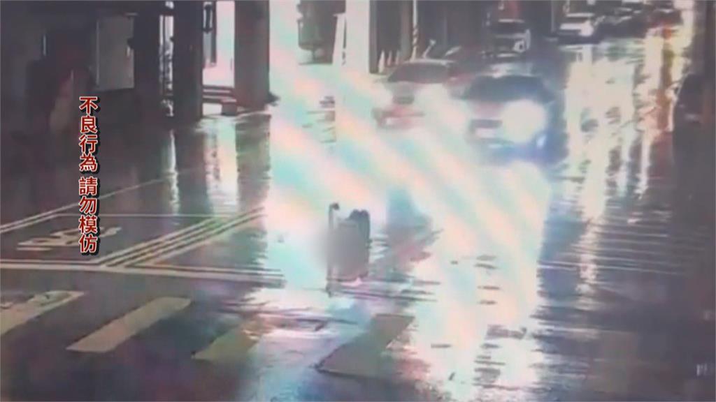 詭異女雨天躺馬路自拍！　後方駕駛險認成「三角錐」