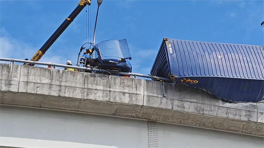 驚險瞬間！國道貨櫃車翻覆卡護欄　車體懸空駕駛一度受困