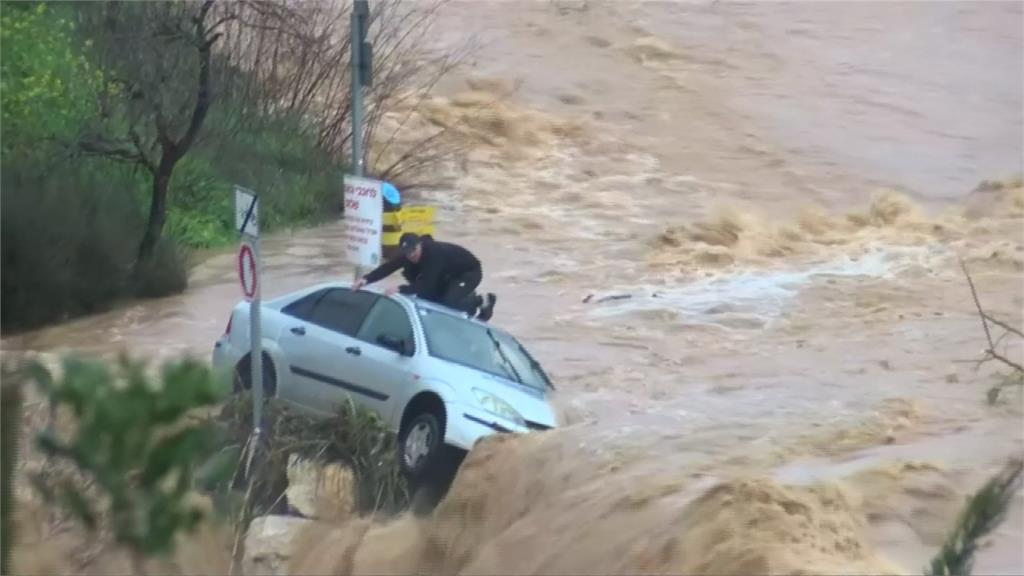 驚險！車受困滾滾洪流中 男爬車頂待救