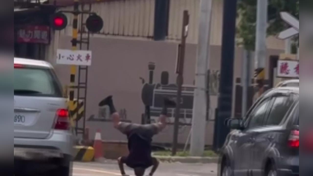 平交道前練蛤蟆功？　特技男頭頂地倒立看火車