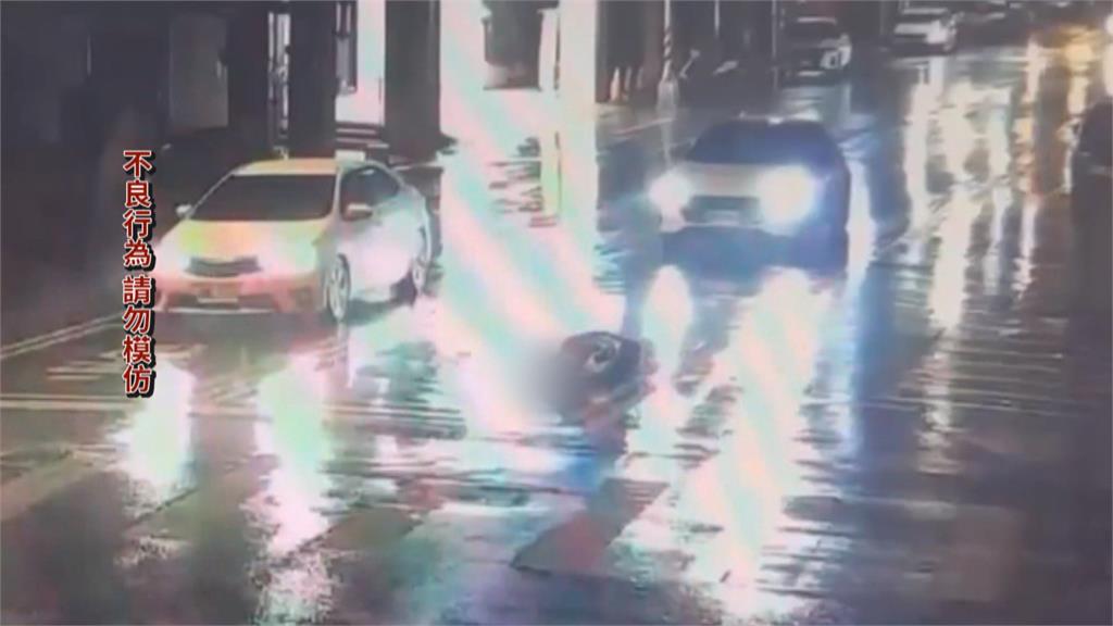詭異女雨天躺馬路自拍！　後方駕駛險認成「三角錐」