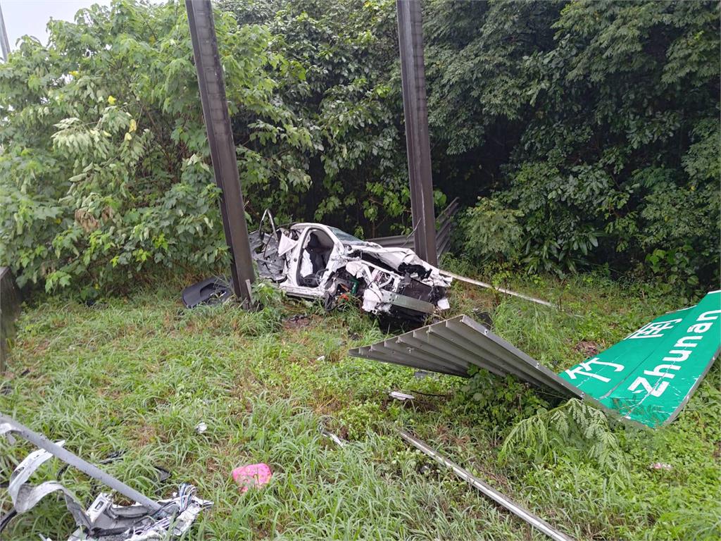 快新聞/颱風天釀禍!國1轎車打滑後飛出護欄 撞斷國道標示「剩一半」