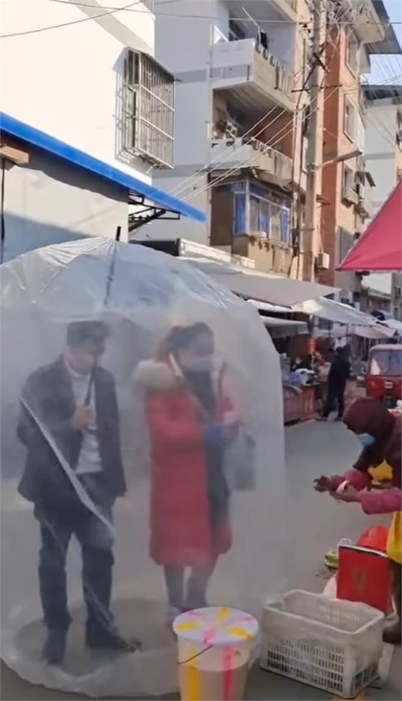 中國防疫奇景！自製金鐘罩「雨傘＋塑膠袋」逛市場　網笑：安全套套？