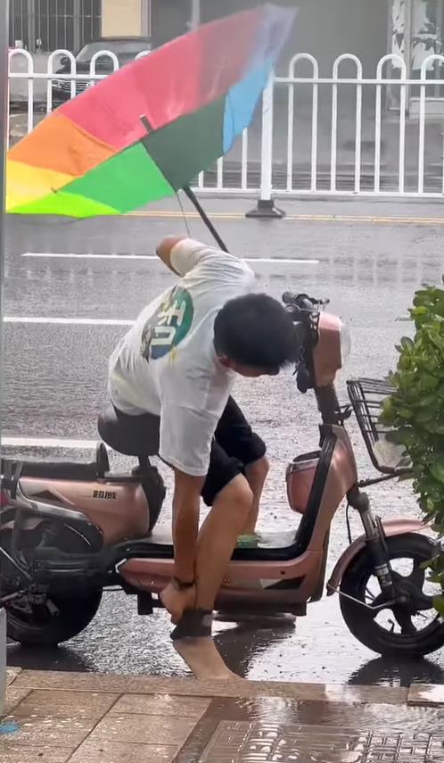 10秒流出超辛酸畫面　撐彩虹傘男穿「這雙鞋」騎車無法動彈