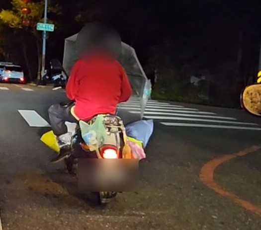 危險駕駛!騎士載兩米寬木製長椅 騎士一手騎車一手撐傘