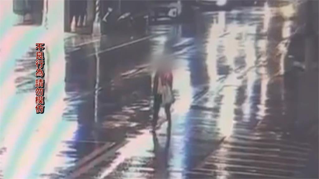 詭異女雨天躺馬路自拍！　後方駕駛險認成「三角錐」
