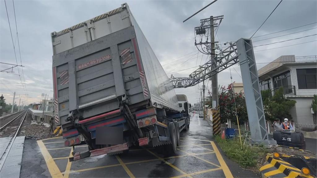 險！前車撞歪限高門　貨櫃車後輪騰空卡平交道