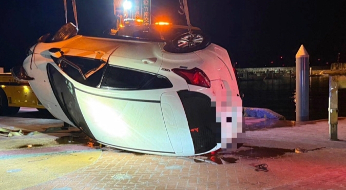漁港邊講電話忘了打P檔 轎車一路滑行 衝進碼頭墜海