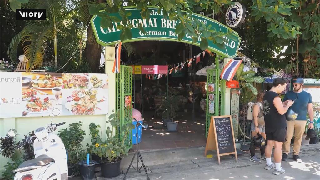 泰國咖啡店創意新招 鑽過柵欄「越窄折扣越多」
