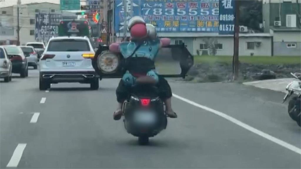 機車雙載危險上路 後座乘客抱著巨型時鐘鏡險象環生